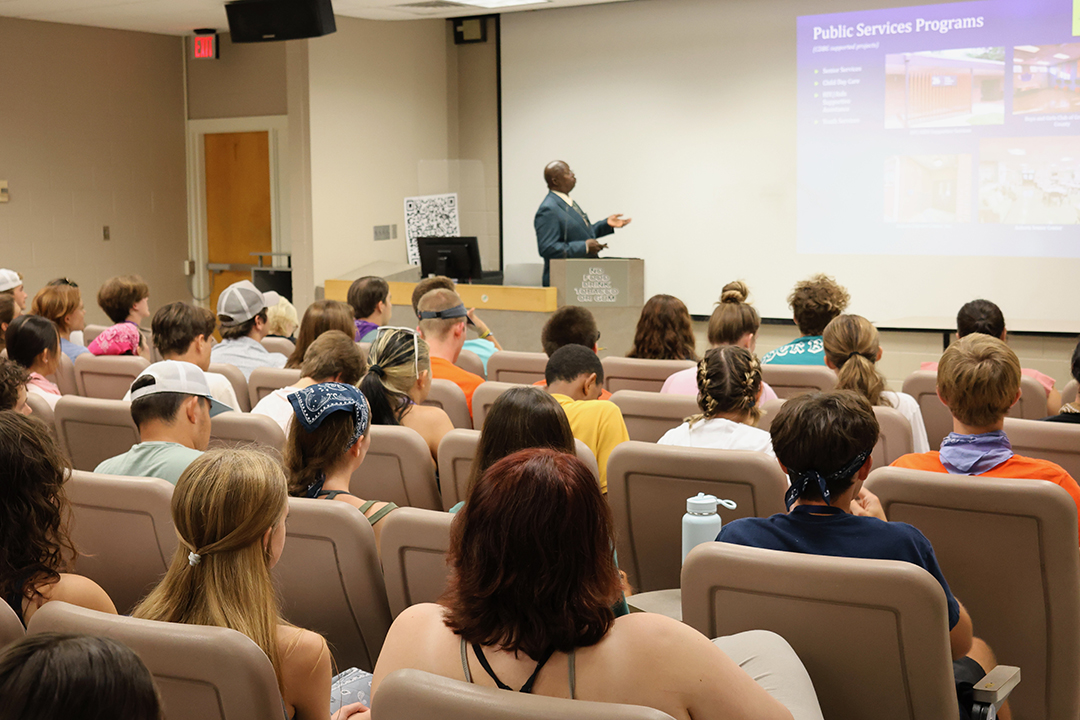 students in a large auditorium listening to a lecture